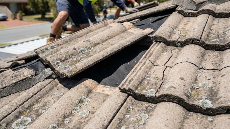 Cracked and displaced concrete roof tiles on a Perth home showing exposed underlayment and potential leak points